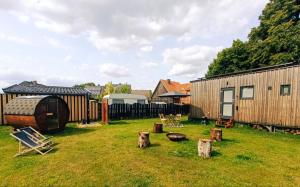 a yard with a wooden building and a fence at Tiny House mit Saunafass im Wendland in Lüchow