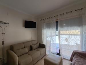 アルマカオ・デ・ペラにあるT3 RC Navegantes - Casas & Papeisのソファと窓のあるリビングルーム