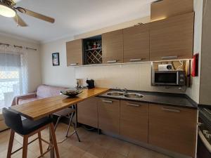 アルマカオ・デ・ペラにあるT3 RC Navegantes - Casas & Papeisのキッチン(木製カウンタートップ、電子レンジ付)