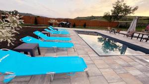a row of blue benches next to a swimming pool at Casa Simion in Sibiu