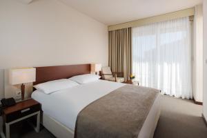 a hotel room with a large bed and a window at Hotel Albatros Plava Laguna in Poreč