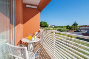 a balcony with a table and chairs and a view at Hotel Albatros Plava Laguna in Poreč