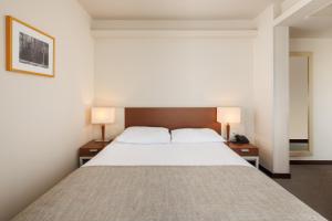 a bedroom with a large bed with two lamps at Hotel Albatros Plava Laguna in Poreč