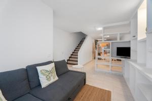 un soggiorno con un divano e una televisione di Jaral Home a Puerto de Santiago