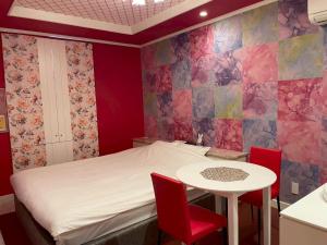 a room with a bed and a table and chairs at ホテルフローレスツーadultonly in Tsubame +22 photos