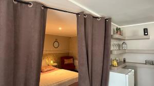 a bedroom with a bed with curtains in it at Escapade cosy in La Celle-sous-Gouzon