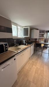 a kitchen with white cabinets and a counter top at Escapade cosy in La Celle-sous-Gouzon
