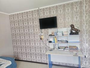 a room with a desk and a tv on a wall at Нурадил in Akchiy