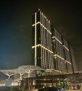 a large building with lights on it at night at 2BR Pollux Habibie Meisterstadt Tower 1 Batam City in Batam Center