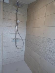 a shower with a shower head in a bathroom at Les Frères Caudron, appartement centre ville in Le Crotoy
