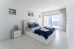 Un dormitorio blanco con una cama y una ventana. en Apartamento T2 Azure Coast, en Nazaré 35 fotos más