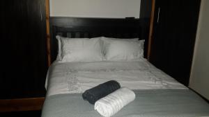 a bed with two rolls of white sheets and pillows at Bellevue Resort Stilbaai Nr.7 in Stilbaai +15 photos