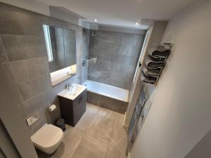 a bathroom with a toilet and a sink and a tub at Panoramic Pondview Penthouse in London +6 photos