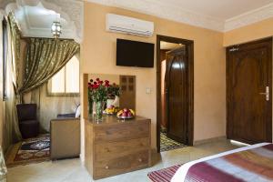 - une chambre avec un lit et une commode fleurie dans l'établissement Marrakech House, à Marrakech