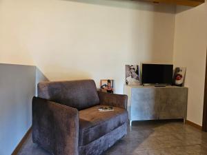 a living room with a chair and a television at Audrey in Montichiari