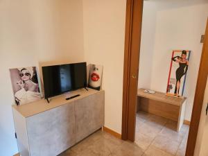 a living room with a flat screen tv on a cabinet at Audrey in Montichiari +5 photos