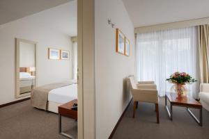 a hotel room with a bed and a table with a chair at Hotel Albatros Plava Laguna in Poreč