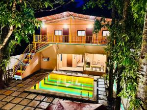 a house with a swimming pool in front of it at Paradise A Social Hostel in Anjuna