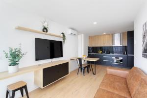 a living room with a couch and a tv on a wall at HostWise - Bright Flat with Balcony and Garage in Vila Nova de Gaia