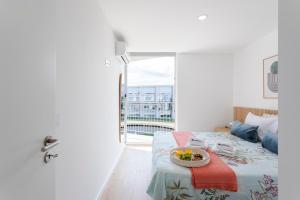 a bedroom with a bed with a bowl of fruit on it at HostWise - Bright Flat with Balcony and Garage in Vila Nova de Gaia +23 photos
