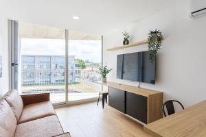 a living room with a couch and a tv at HostWise - Bright Flat with Balcony and Garage in Vila Nova de Gaia