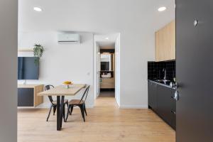 a kitchen and dining room with a table and chairs at HostWise - Bright Flat with Balcony and Garage in Vila Nova de Gaia