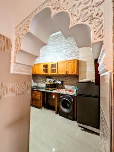 a kitchen with a refrigerator and a stove top oven at Appartement dans la médina in Essaouira