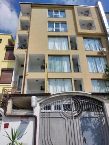 a tall building with a gate in front of it at Guest house WEST in Sunny Beach
