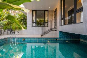 a swimming pool in the middle of a house at SaffronStays Ibiza - 4BR Nerul villa, glass-bottom pool into living, ensuite rooms, rooftop party zone near Candolim in Nerul +30 photos