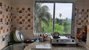 a kitchen with a window and a sink and a stove at Peace Abode in Dibrugarh