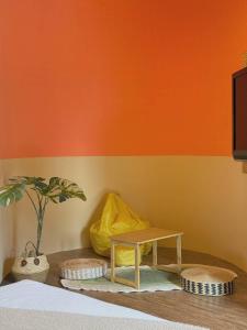 a bedroom with orange and yellow walls and a table at E-Ping Castle Hotel in Nanwan