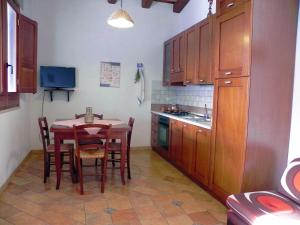 カステッルッツォにあるMastromario Apartmentsのキッチン(木製キャビネット、テーブル、椅子付)