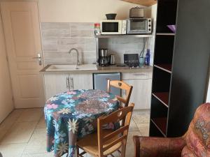 a small kitchen with a table and a sink at l'orchidée in Talais