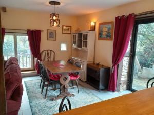 a living room with a table and a dining room at Badger Cottage in Salagnac