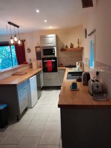 a kitchen with a stove top oven next to a counter at Badger Cottage in Salagnac +10 photos