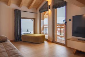 a living room with a couch and a large television at Chalet Le Rokh in Landry