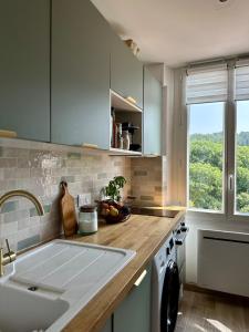 a kitchen with a sink and a counter with a window at Nid Provençal - cœur de Village in Callas