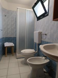 Un baño con inodoro, lavabo y ducha. en Verdura Country LT, en Sciacca