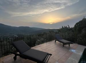 un patio con 2 sedie, un tavolo e un tramonto di Soller Sunset Escape - Private Pool and Sea Views a Fornalutx