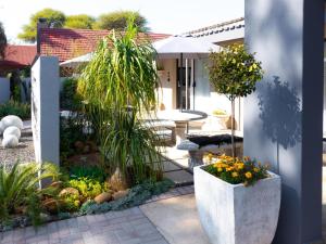 a patio with a table and some plants at Relmies Place in Modimolle