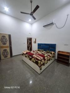 a bedroom with a bed and a ceiling fan at Kamal kishori Dham Guest house in Barsāna