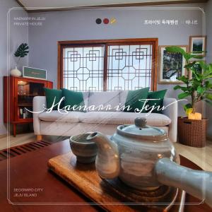 a living room with a couch and a pot on a table at Haenarr Hanok Stay in Mandarin Orchard, 100m from Sea in Seogwipo