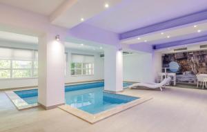 a swimming pool in a house with a purple ceiling at Apartmani Monaco in Ploče