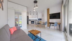 a living room with a couch and a table at Ukiel, Sun & Snow in Olsztyn