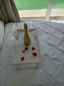 a table with two glasses and a bottle on a bed at Casa Ozon in Vulcan