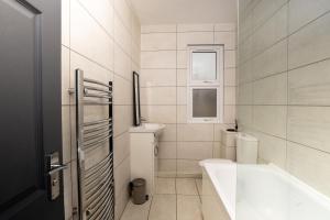 a bathroom with a tub and a toilet and a sink at Priory house - home away from home in Dartford +13 photos