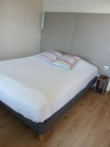 a bed with two pillows on it in a room at Campanile Orléans Ouest ~ La Chapelle-St-Mesmin in La Chapelle-Saint-Mesmin