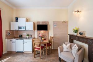 cocina y comedor con mesa y sofá en Komfort Apartment Römersberger - 4, en Vogtareuth