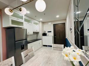 Una cocina con gabinetes blancos y un refrigerador negro. en Tommy Home in Soho Central Distric 1 SaiGon, en Ho Chi Minh 30 fotos más