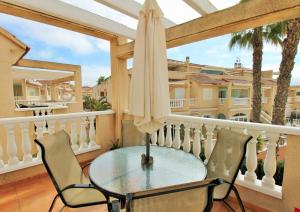 a balcony with a table and chairs and an umbrella at Costa Orihuela Penthouse with Pool View in Los Altos